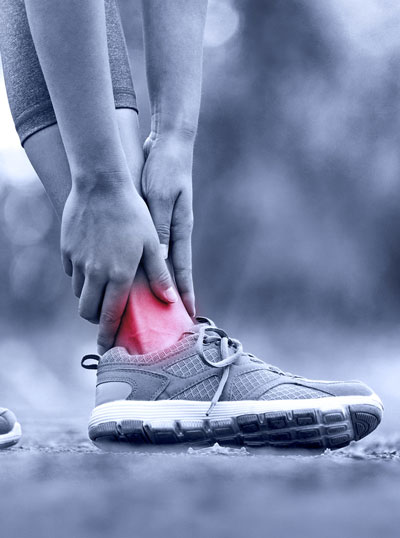 female athlete holding their ankle in pain