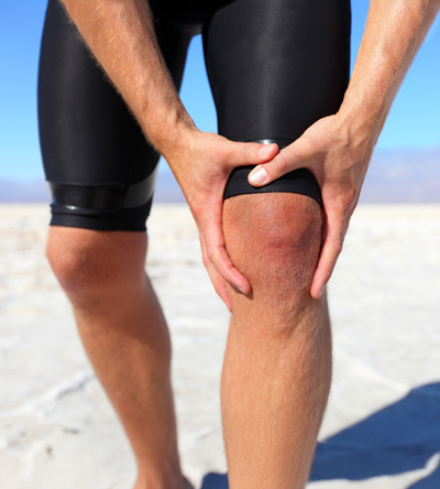 athlete holding knee in pain