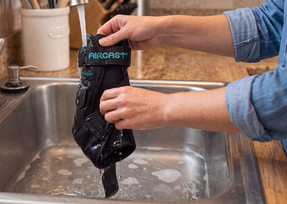 Aircast® Airsport Ankle Brace being washed in the kitchen sink