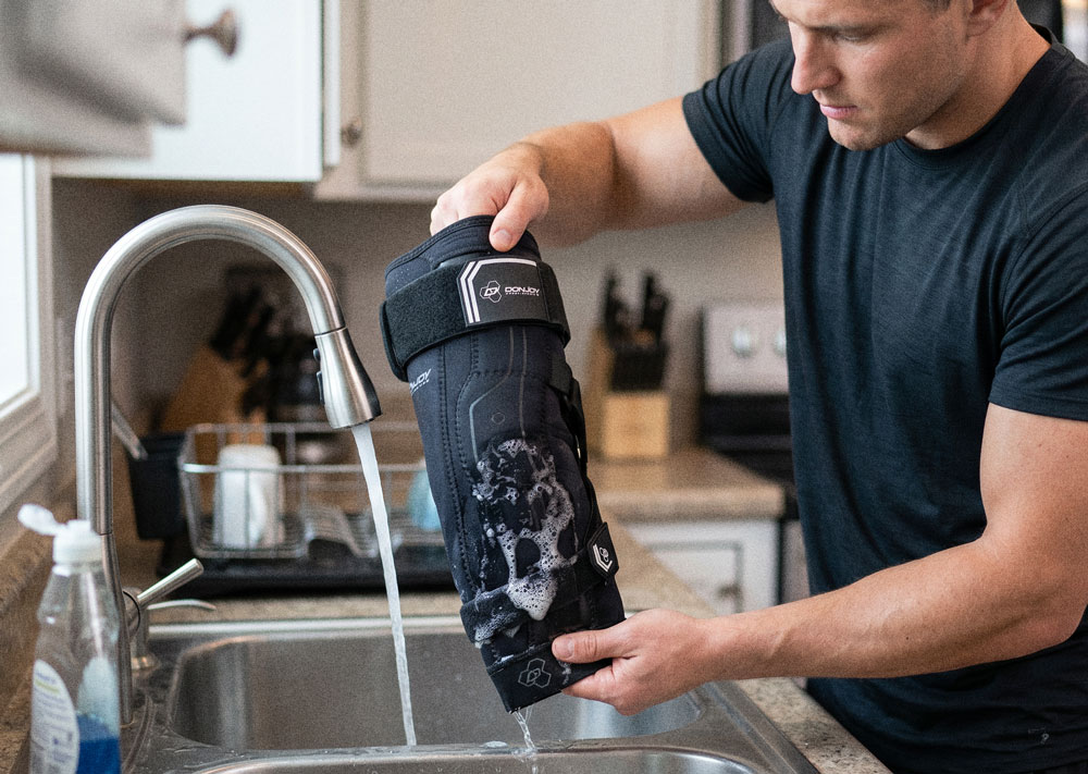 DonJoy Performance Bionic™ Elbow Brace II being washed in a kitchen sink