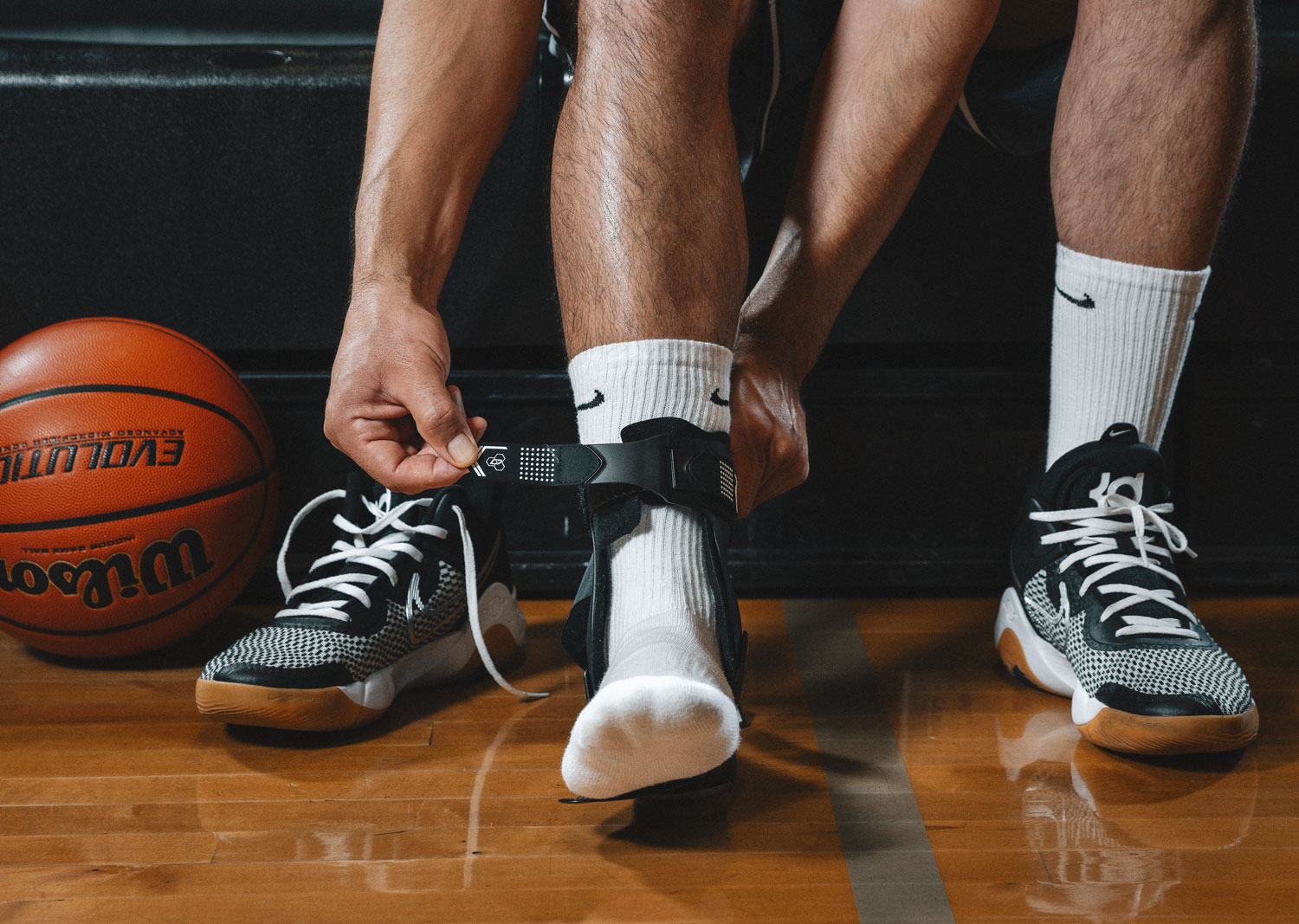 DonJoy Performance Bionic Stirrup Ankle Brace worn by an athlete kneeling on a field