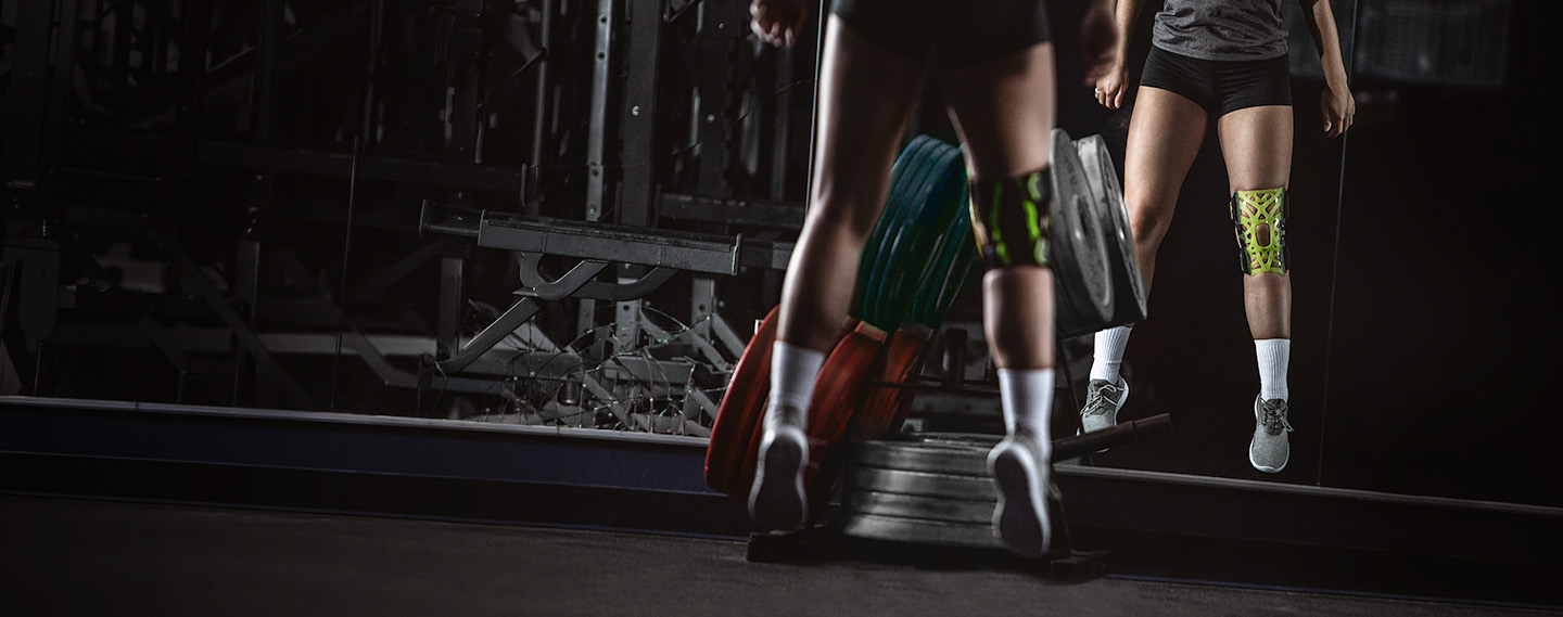 Athlete wearing the DonJoy Performance Webtech Knee Brace while working out in the gym