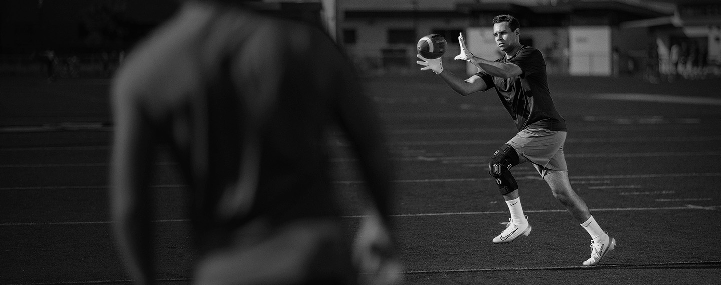 Athlete wearing FullStop Knee Brace catching a football