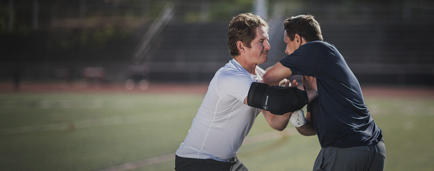 Athlete wearing the DonJoy Performance Elbow Brace playing football