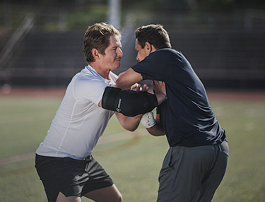 Athlete wearing the DonJoy Performance Elbow Brace playing football