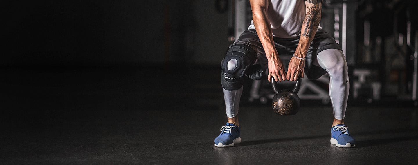 Athlete wearing bionic knee brace doing a deadlift at the gym