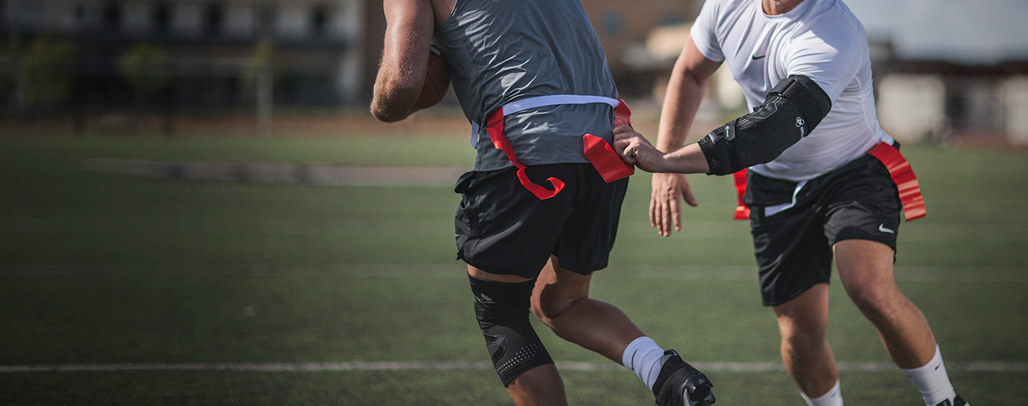 Athlete wearing elbow brace pulling a flag