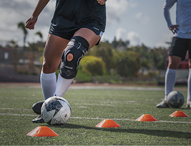 Athlete wearing Bionic Drytex Hinged Knee Sleeve while doing soccer drills
