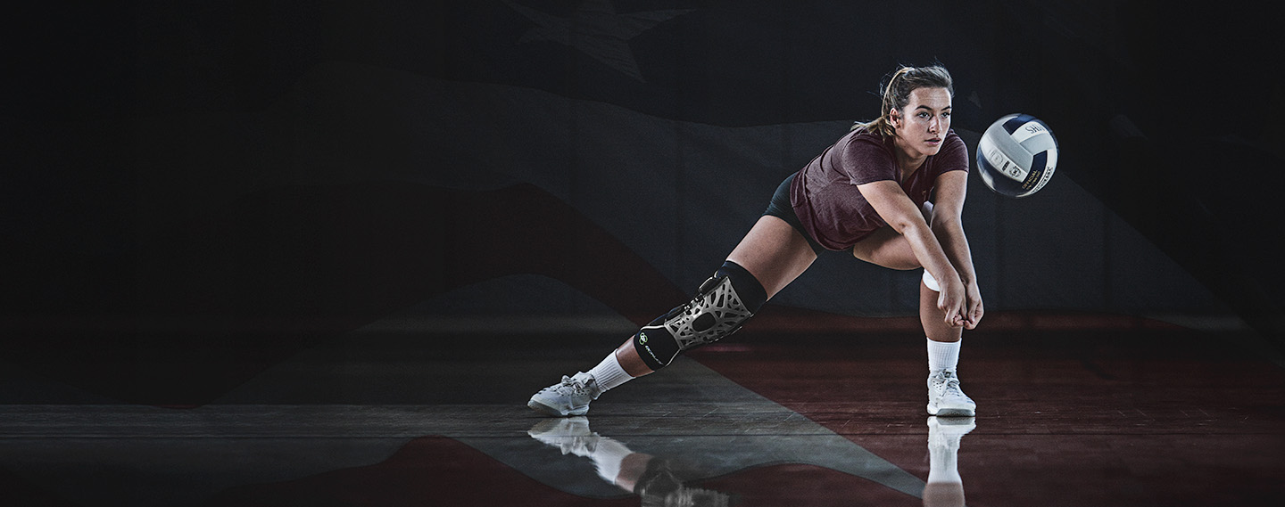 Volleyball athlete hitting ball wearing knee brace