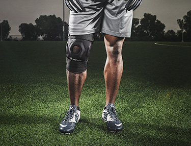 Athlete wearing bionic knee brace stand on a field