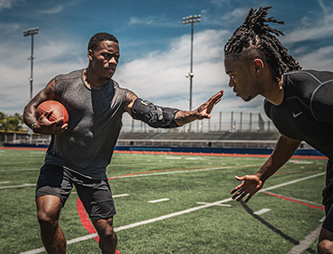 Athlete wearing elbow brace running with the football